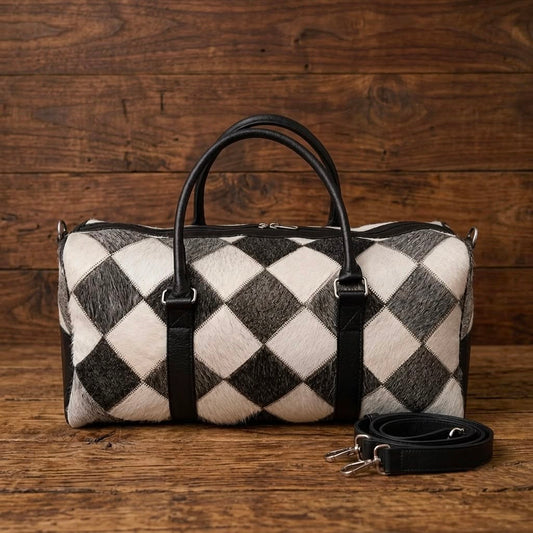 Black and white cowhide duffel bag with detachable shoulder strap