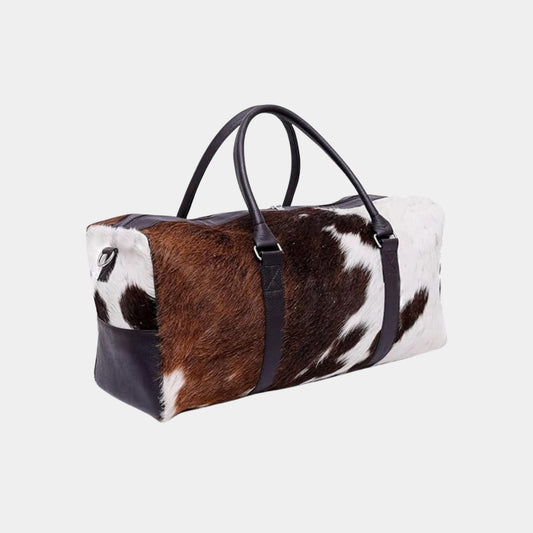 Brown and white cowhide duffel bag angled side view