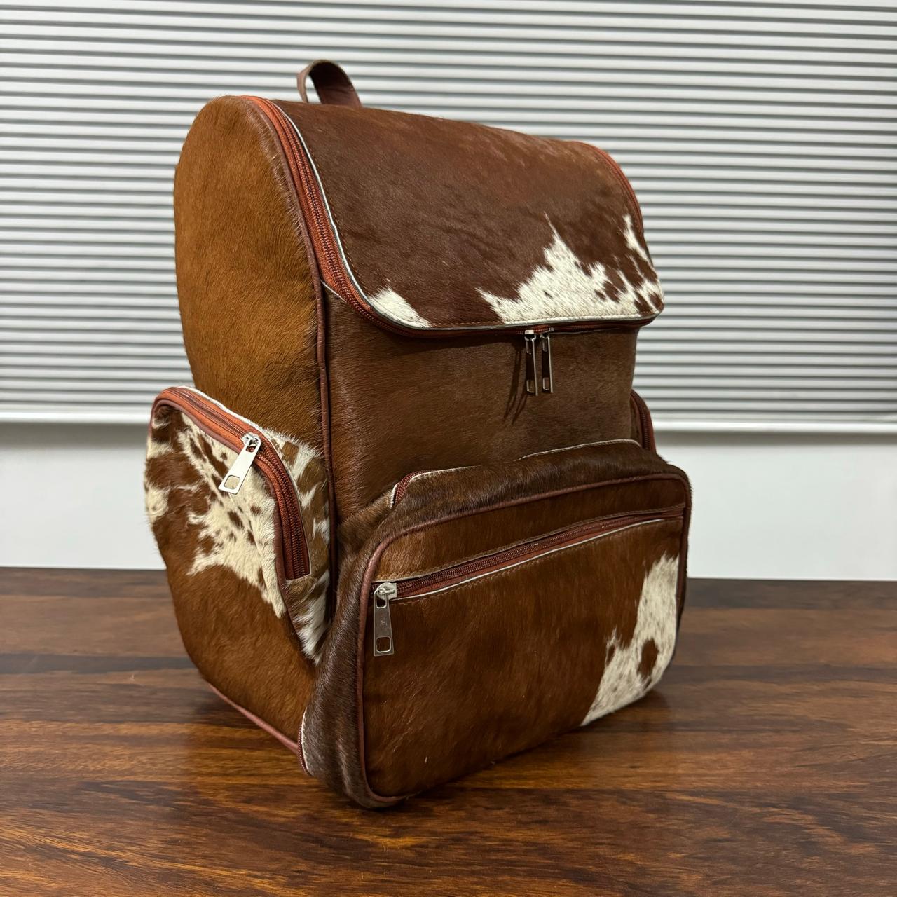 Cowhide backpack side view showing adjustable leather shoulder straps