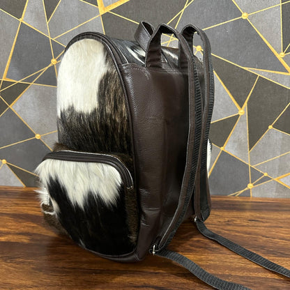 Cowhide diaper backpack with removable suitcase strap attached