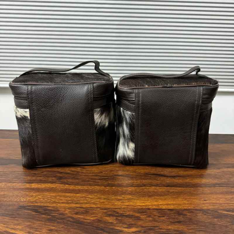 back veiw of Black and white cowhide cosmetic and toiletry travel bags with leather trim and zipper closure