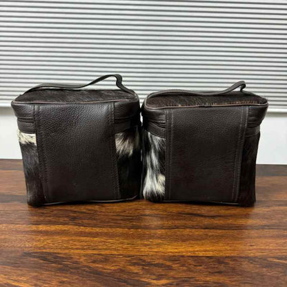 back veiw of Black and white cowhide cosmetic and toiletry travel bags with leather trim and zipper closure