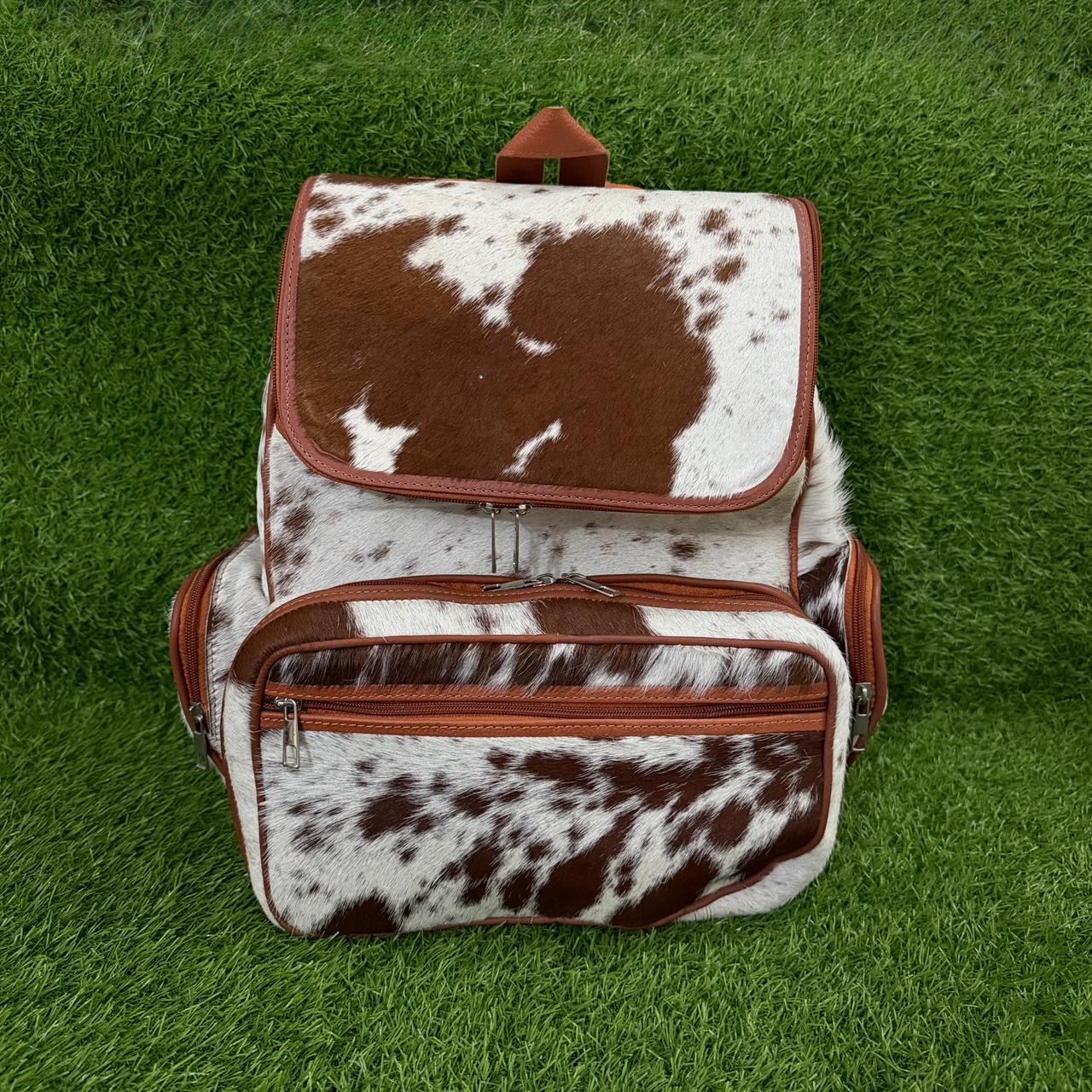 Front zip pocket and tan leather trim detail on backpack