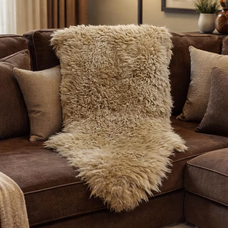 Beige sheepskin rug draped over a brown sofa