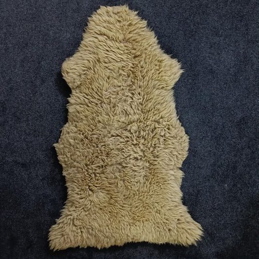 Beige single pelt sheepskin rug showing its natural shape and wool texture
