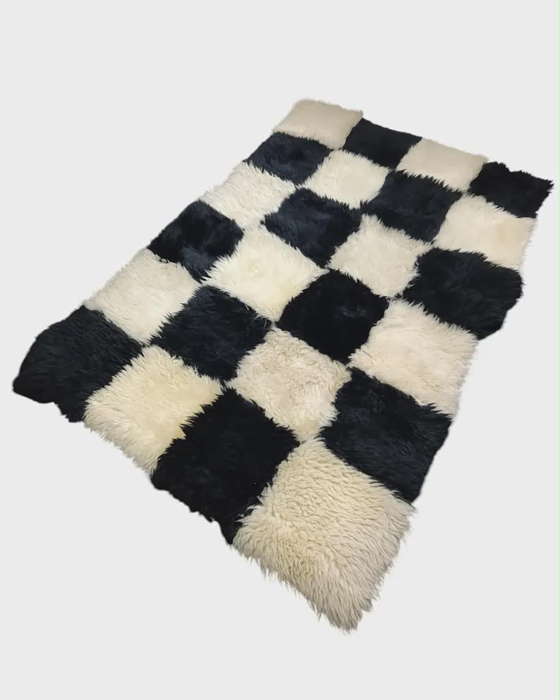 Black and white checkerboard patchwork sheepskin rug viewed from an angle