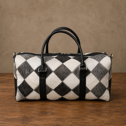 Black and white cowhide duffel bag with leather handles