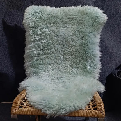 Blue grey sheepskin pelt rug displayed on a woven chair