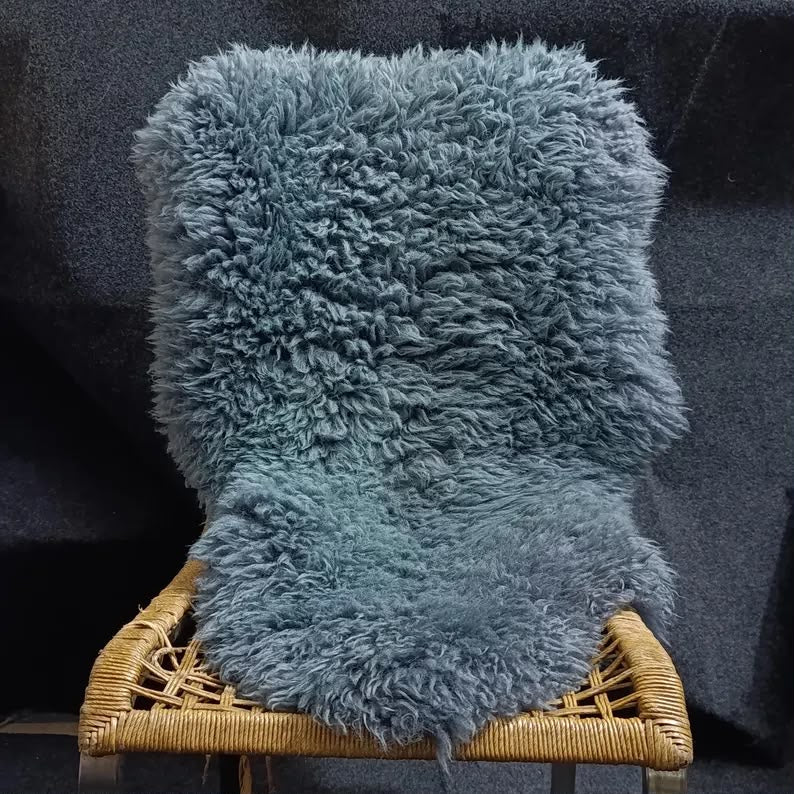 Blue sheepskin pelt rug styled on a woven chair