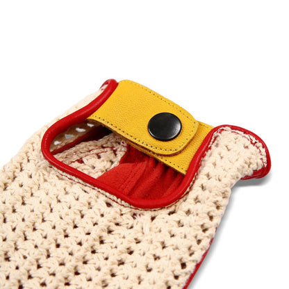 Close-up of a crocheted beige bag or pouch with a bright red trim and a yellow flap closure secured by a black snap button, shown on a white background.