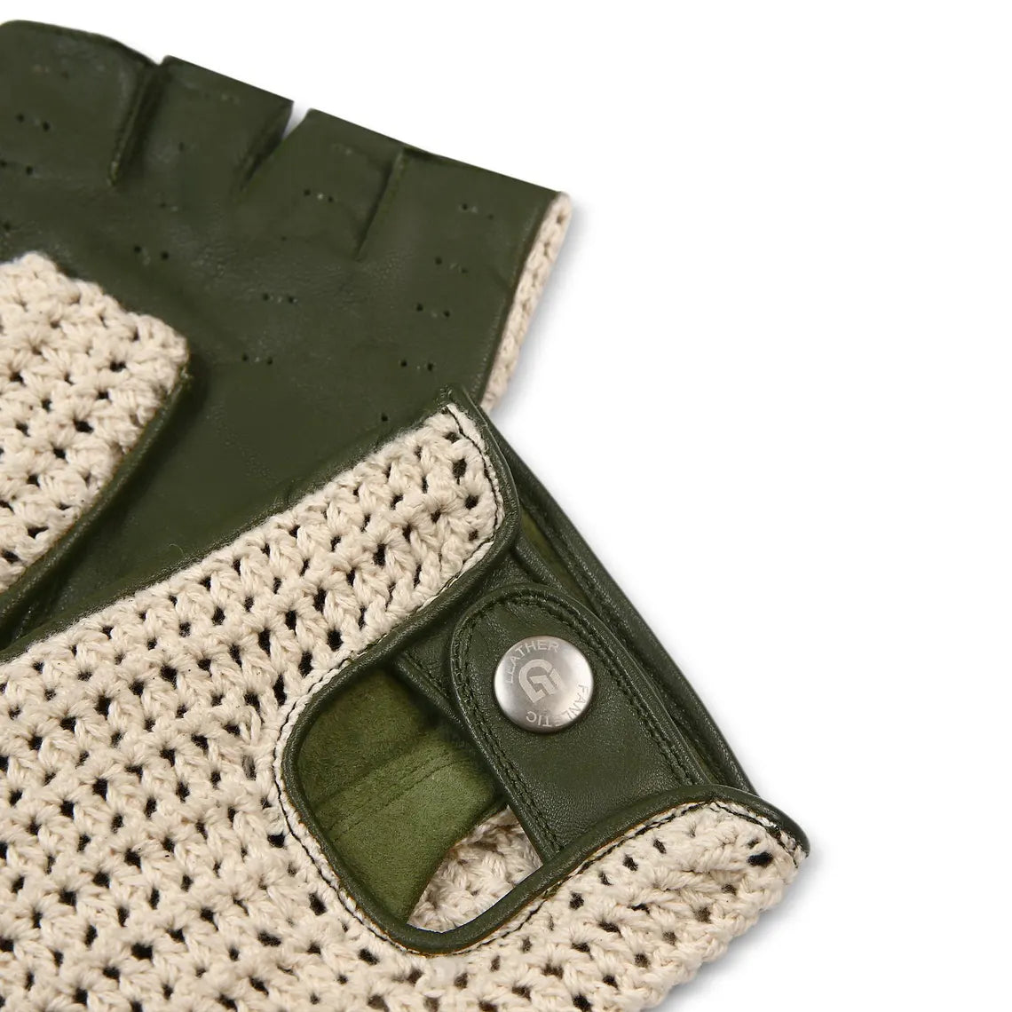 Close-up of a fingerless glove showing an olive green leather back with perforated texture and a cream-colored knit palm, secured by a silver snap button.