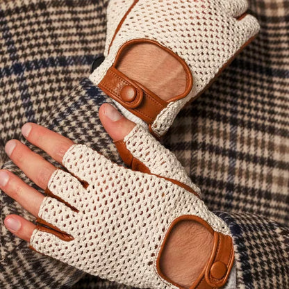 Beige fingerless gloves with brown leather accents on a plaid fabric background