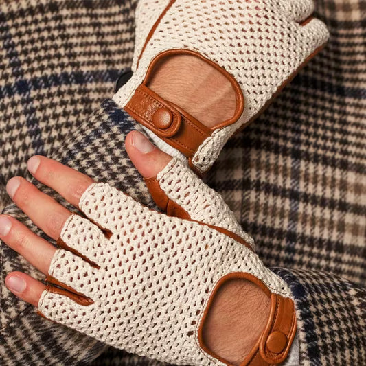 Beige fingerless gloves with brown leather accents on a plaid fabric background