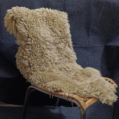 Natural beige sheepskin pelt styled on a lounge chair