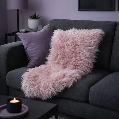 Warm pink sheepskin rug draped over a charcoal sofa