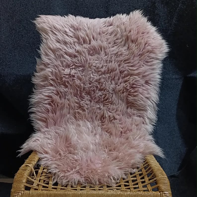 Warm pink single pelt sheepskin rug displayed on an accent chair