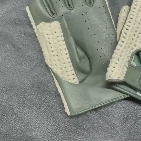 A pair of fingerless gloves with olive green leather panels and a beige open-knit mesh back