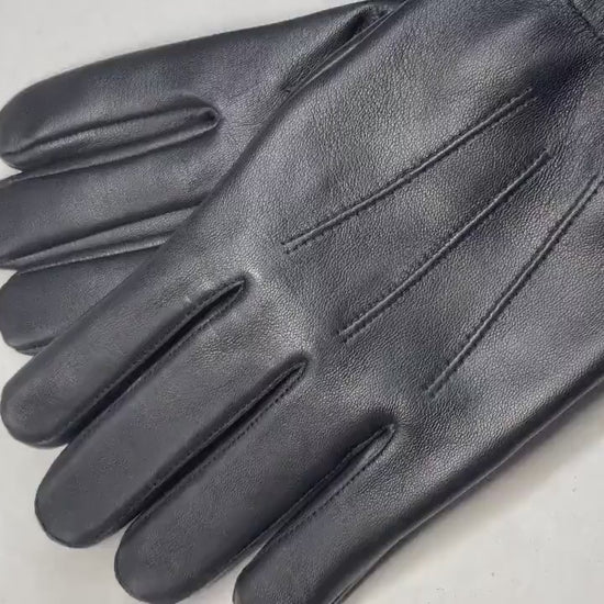 video of A pair of cream-colored open-knit fingerless gloves with brown leather accents, shown on a clean white background.