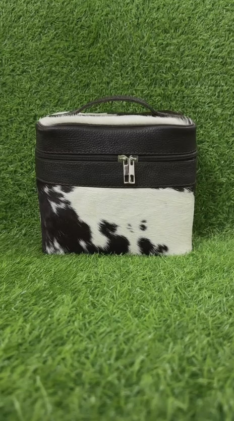 360 veiw of Black and white cowhide toiletry bag with zipper closure and top handle