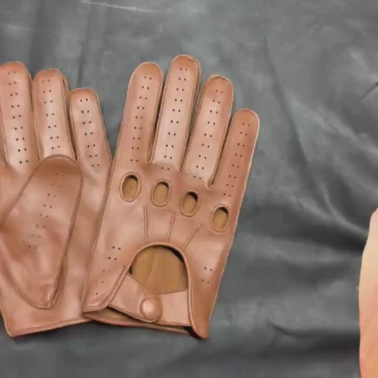 video of A pair of brown leather driving gloves with perforated ventilation holes and button closures, displayed on a clean white background.