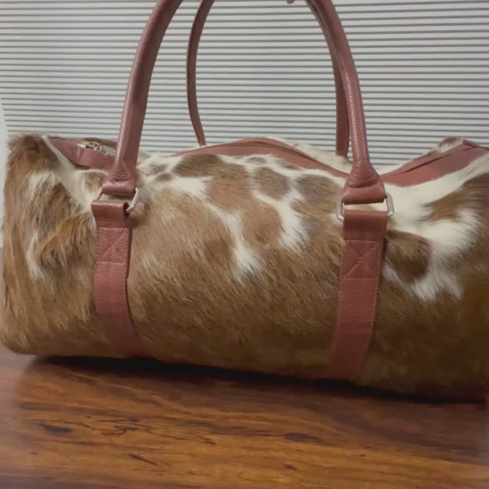 360-degree view of brown and white cowhide leather duffel bag