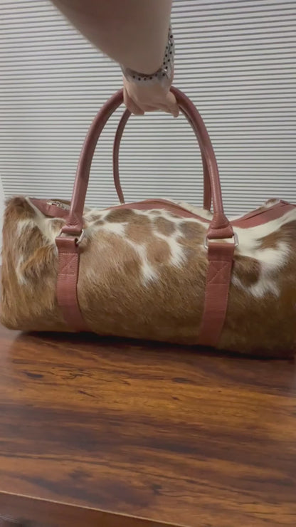 360-degree view of brown and white cowhide leather duffel bag
