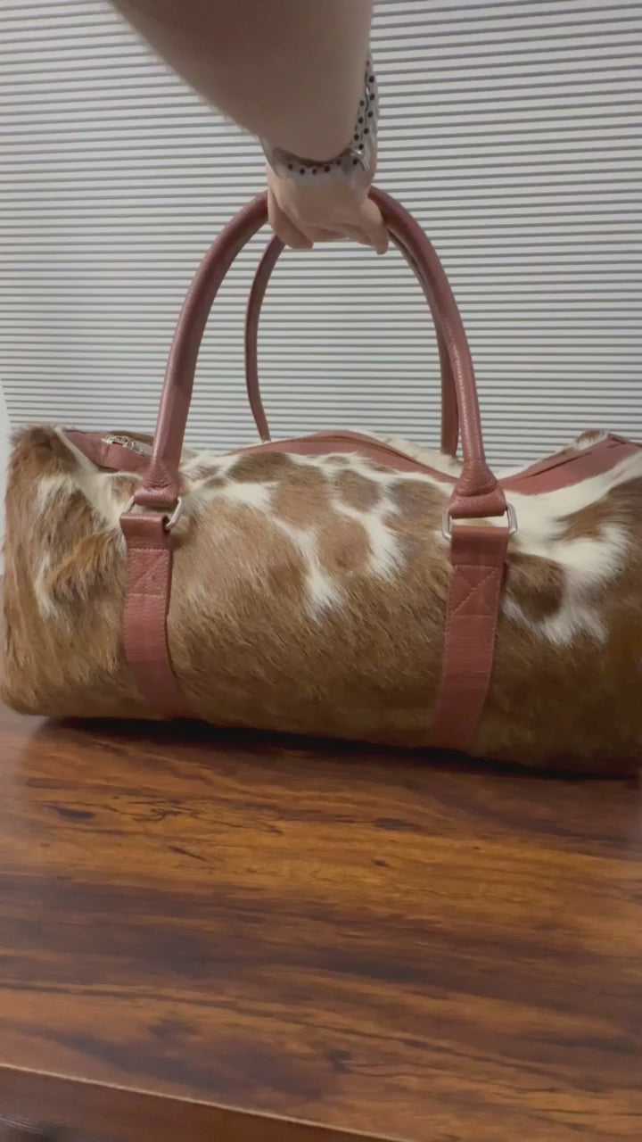 360-degree view of brown and white cowhide leather duffel bag