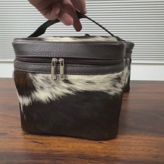 360 veiw of Black and white cowhide cosmetic and toiletry travel bags with leather trim and zipper closure