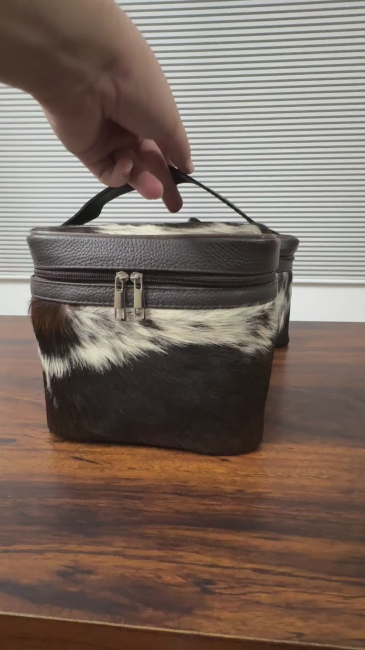360 veiw of Black and white cowhide cosmetic and toiletry travel bags with leather trim and zipper closure