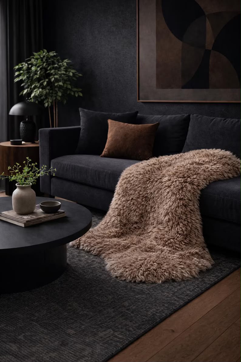 Sandy brown sheepskin rug draped over a dark sofa in a modern living room