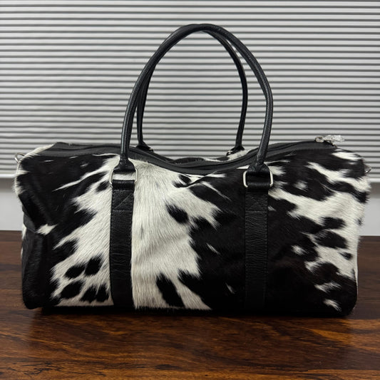 Spotted black and white cowhide duffel bag front view