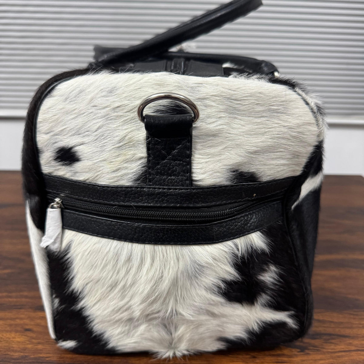 Close-up of natural spotted cowhide texture on duffel bag