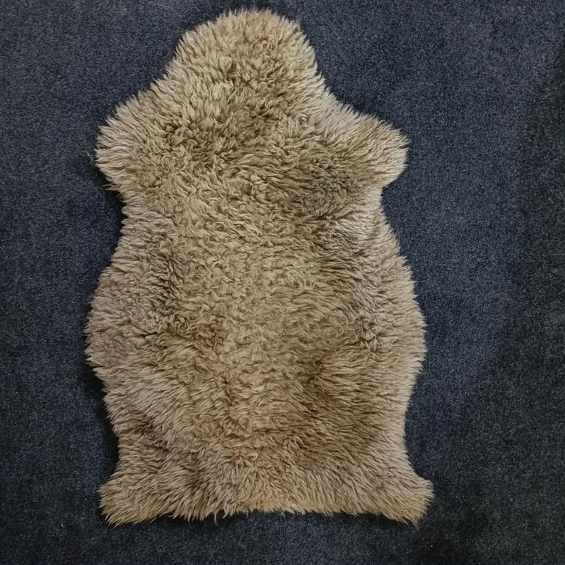 Taupe sheepskin pelt rug showing its natural shape and wool texture